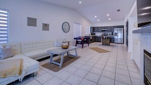 Una sala de estar moderna con un sofá, una mesa de centro y una cocina al fondo.