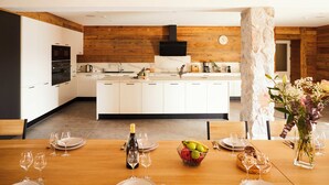 Una cocina moderna con armarios blancos, una pared decorativa de madera y una isla central.