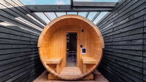 A wooden sauna with a circular entrance, benches inside, and a door with a sign. - THE VILLA SEIFUMEIGETSU (Shiraoi)