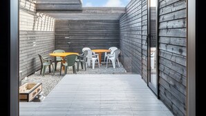 A framed view of a wooden deck with a table and chairs, a pair of shoes, and a wooden wall. - THE VILLA SEIFUMEIGETSU (Shiraoi)