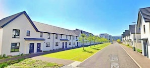 Una hilera de casas modernas con césped cuidado y cielo despejado.