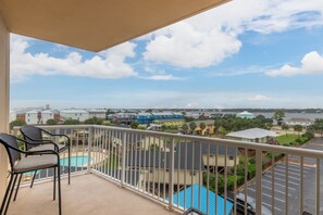 A balcony with a view of a swimming pool and surrounding buildings. - Crystal Tower 409 (Gulf Shores)