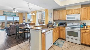 A spacious kitchen with wooden cabinets, a built-in microwave, and a dishwasher. - Crystal Tower 409 (Gulf Shores)