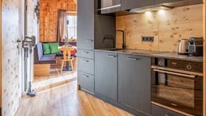 A modern kitchen with grey cabinets, a stainless steel range hood, and a Siemens oven. - Luxurious apartment with a sauna on the slope (Weißpriach)