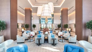 A spacious lobby with modern furniture, a central seating area, and a large chandelier. - Address Residence Fujairah by Bespoke (Sharm)