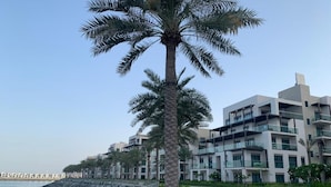 A modern building with balconies and a paved walkway. - Address Residence Fujairah by Bespoke (Sharm)