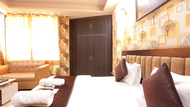 Une chambre d’hôtel comprenant un lit, un canapé, un bureau et une armoire.
