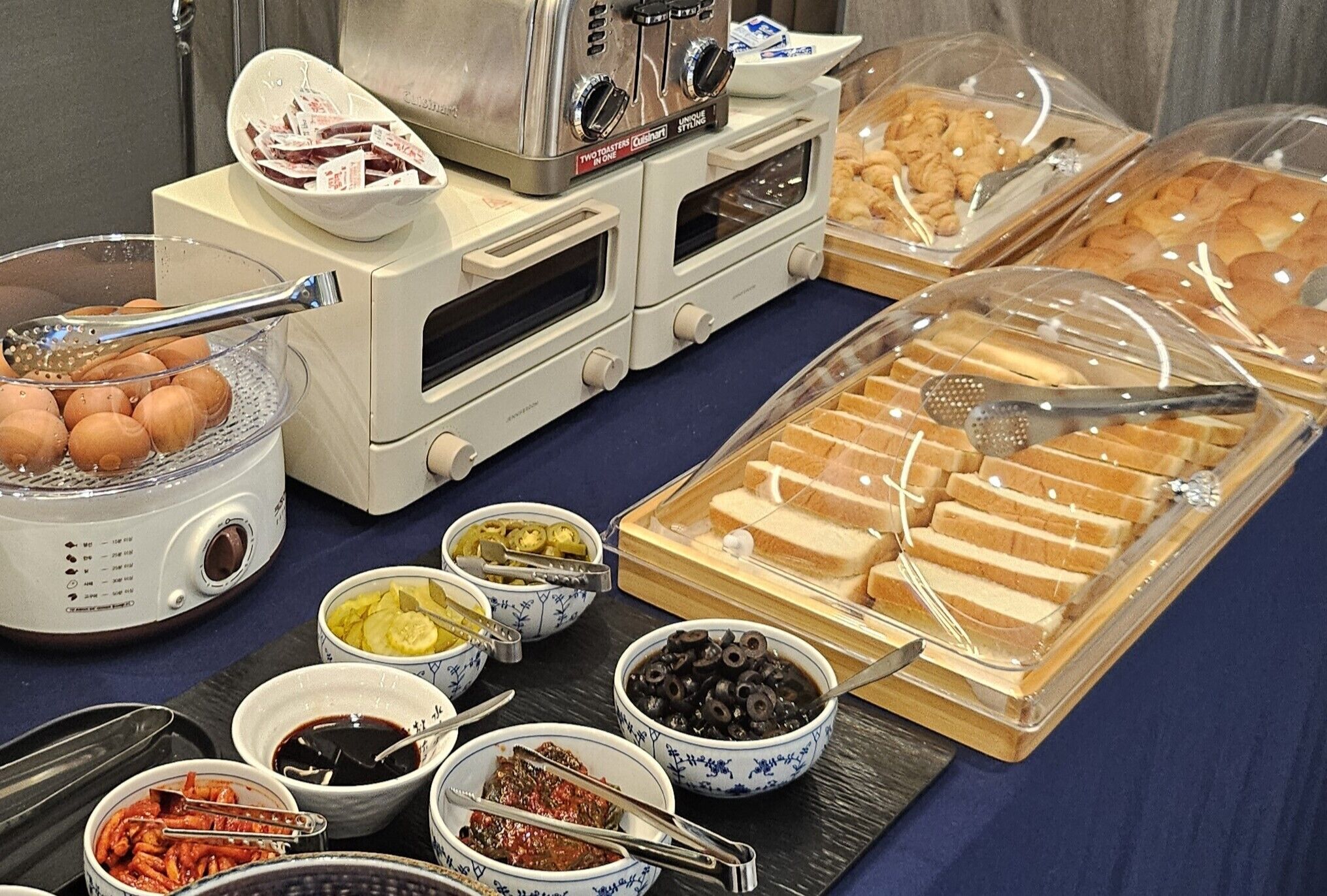 A buffet with various food items including bread, eggs, and condiments.