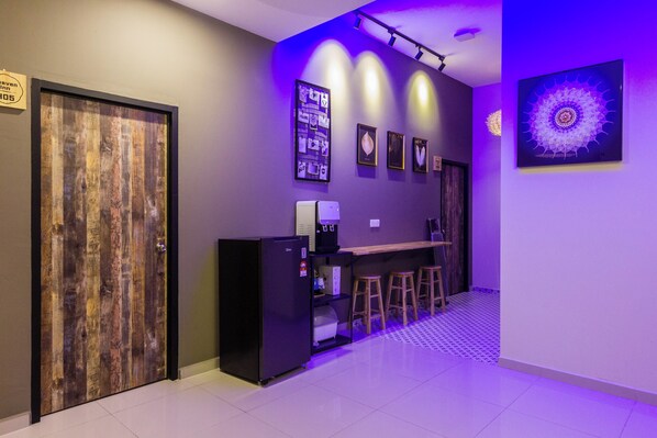A modern kitchen with a refrigerator, a coffee machine, and a bar area with stools. - Heaven 5BR Garden Inn by uBook (Butterworth)