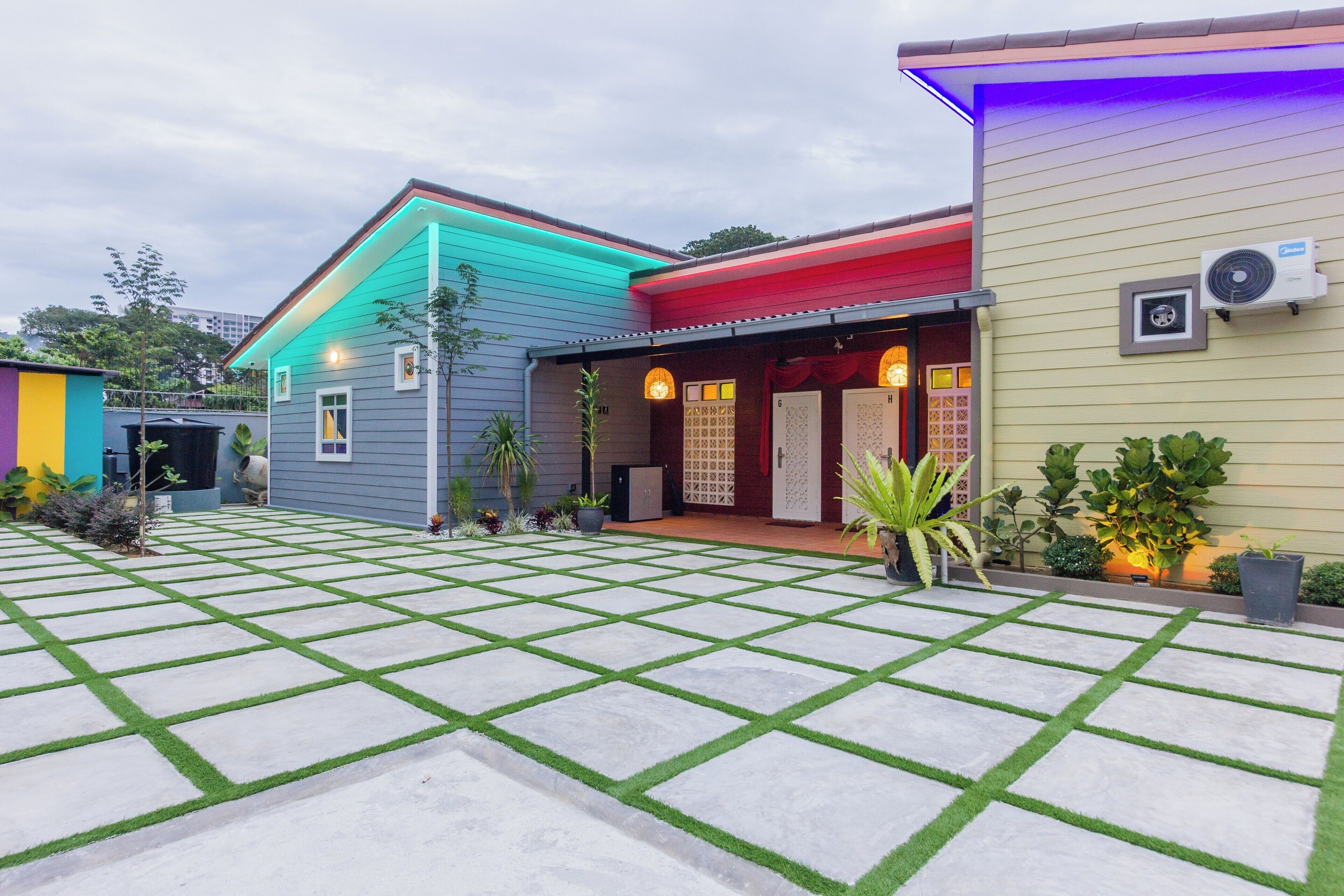 A residential area with a paved courtyard, colorful houses, and potted plants.