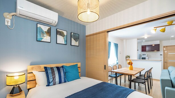 Moderni hotellihuone, jossa on suuri sänky, työpöytä ja ruokailutila.
