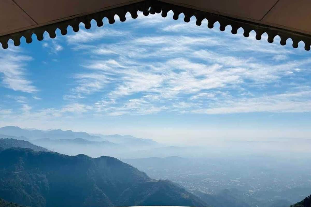 A view from a covered area with a clear sky and distant mountains.