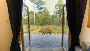 Ein Zimmer mit einer Schiebeglasdoor zu einem Kiesweg und einem Garten.