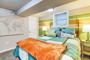 A bedroom with a bed, a world map on the wall, and a window with patterned curtains. - 1 Mi to Dtwn Casper: Homey Getaway w/ Yard! (Casper)
