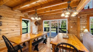 L’intérieur d’un chalet en bois, avec une table à manger, des bancs et un canapé.