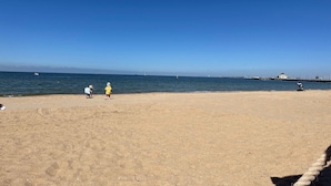 A beach with a clear sky, calm sea, and a pier in the distance. - LUXURY LIVING - ICONIC ST KILDA BEACH LOCATION ** ONE MONTH SHORT STAYS **
 (St Kilda)