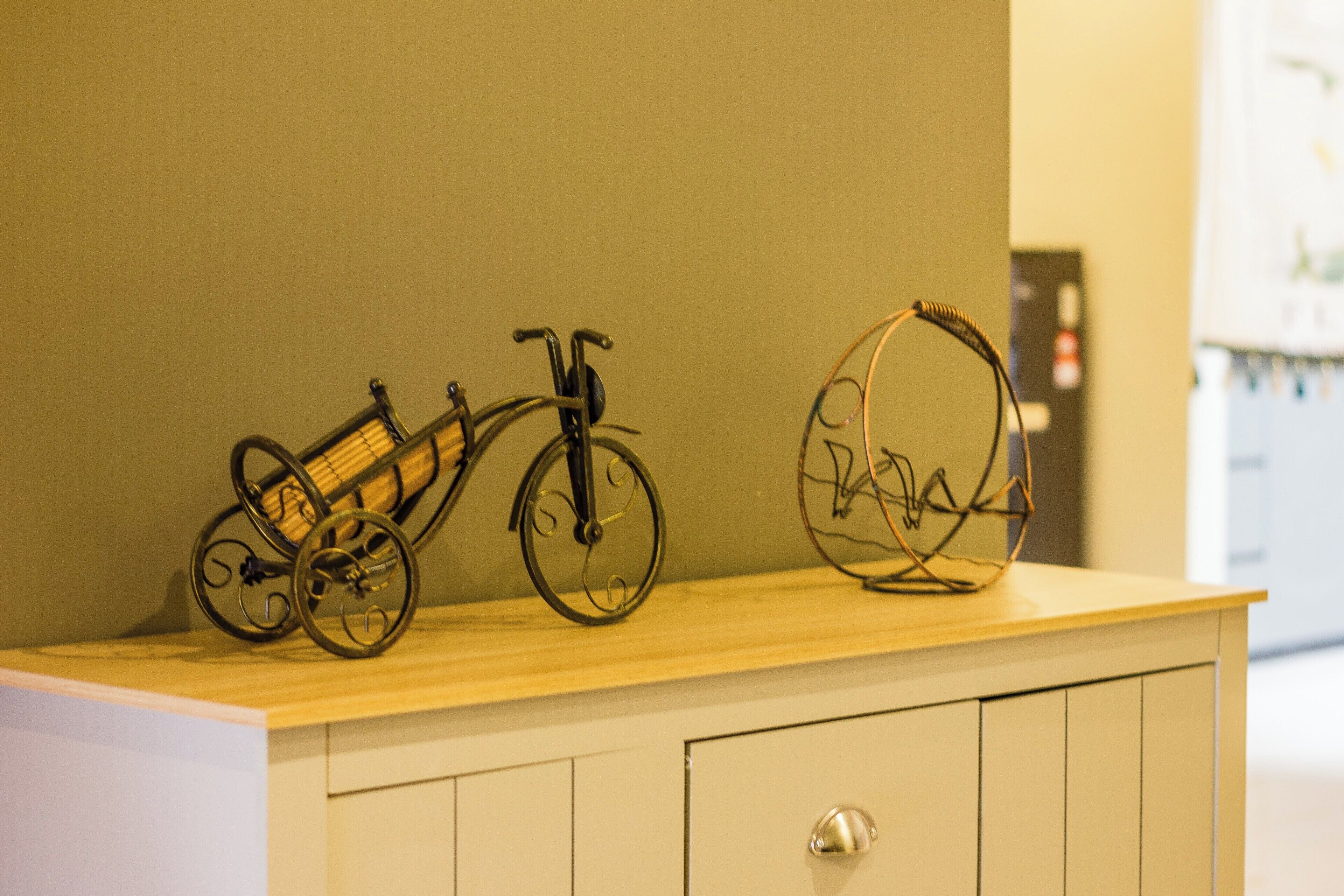 A wooden shelf with three metal sculptures of bicycles.