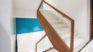 A staircase with wooden handrails and white steps. - Glitz Hotels DR Residency (Mumbai)