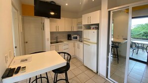 A compact kitchen with a white countertop, a microwave, a refrigerator, and a ceiling fan. - Magical Sunsets at Coco Sunset Hills (Playas del coco)