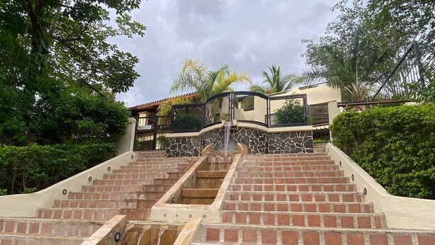 A multi-level outdoor water feature with cascading steps and a stone pathway. - Magical Sunsets at Coco Sunset Hills (Playas del coco)