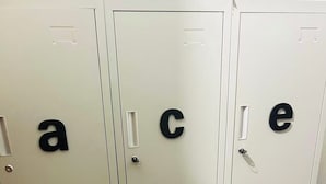 A row of metal lockers with letters on the doors.