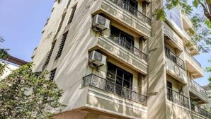 A multi-story building with balconies and air conditioning units. - PS By Glitz Hotels (Navi Mumbai)