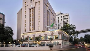 A modern hotel with a prominent sign, multiple floors, and a parking area. - The Fern Residency Ahmedabad, Ellisbridge, Series by Marriott (Ahmedabad)