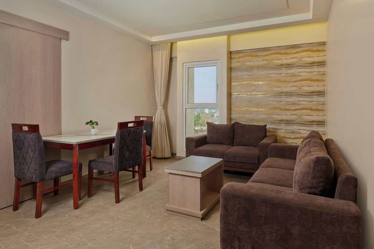 A living room with a sofa, chairs, a coffee table, and a dining table.