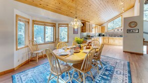 A spacious kitchen with wooden cabinets, a dining table with chairs, and large windows. - Hansel by AvantStay | Pool Table, 5mins to Skiing (Truckee)
