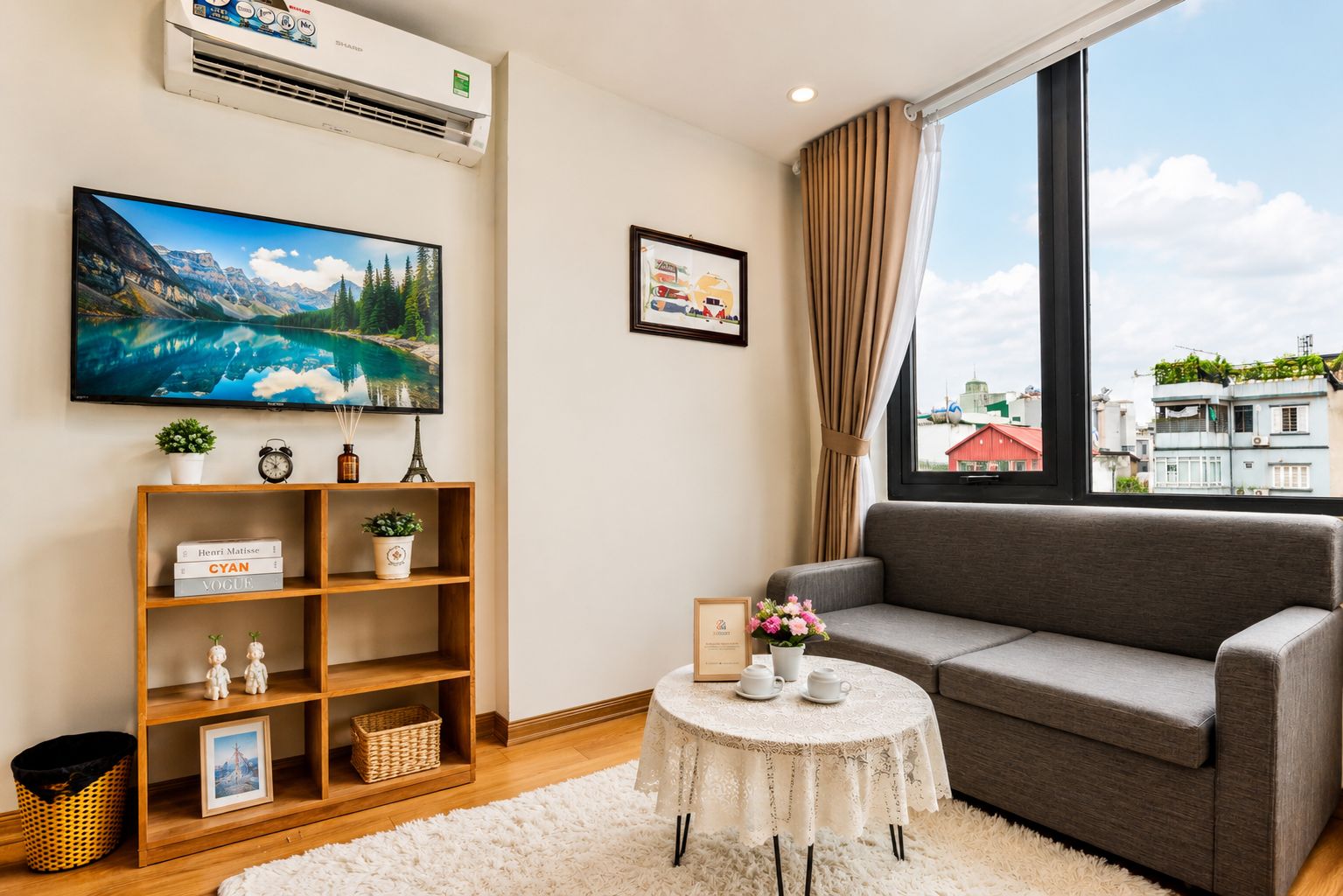 A modern living room with a grey sofa, a round coffee table, and a bookshelf.