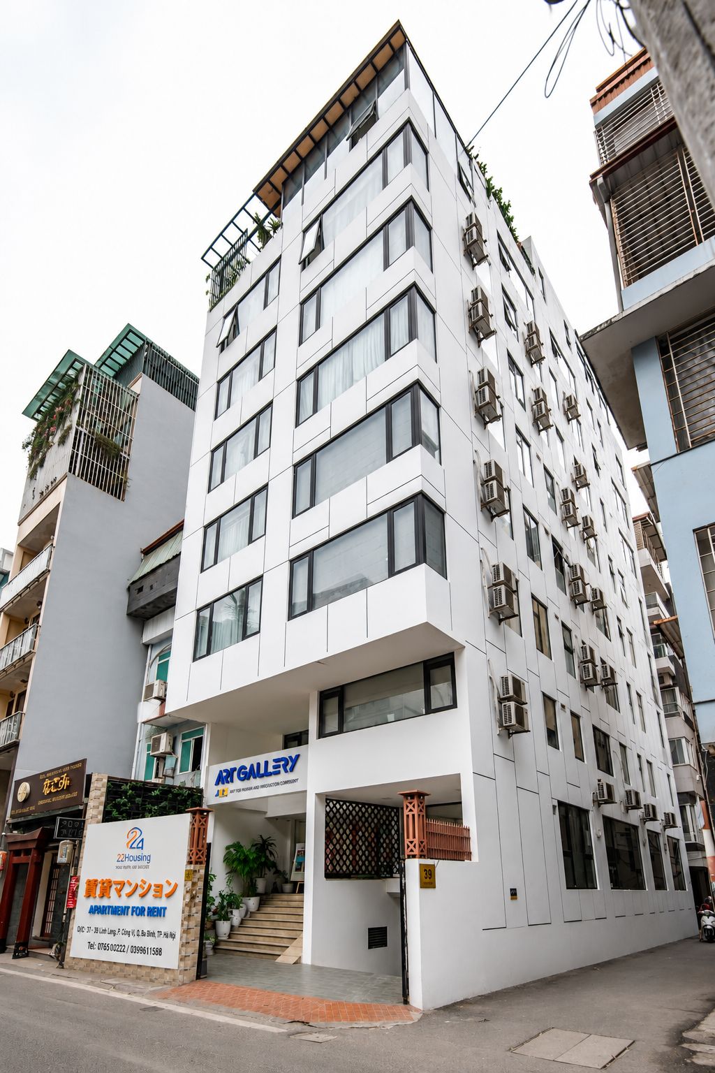 Un immeuble à plusieurs étages doté d’une architecture moderne, caractérisé par une façade plane, de grandes fenêtres et des balcons.