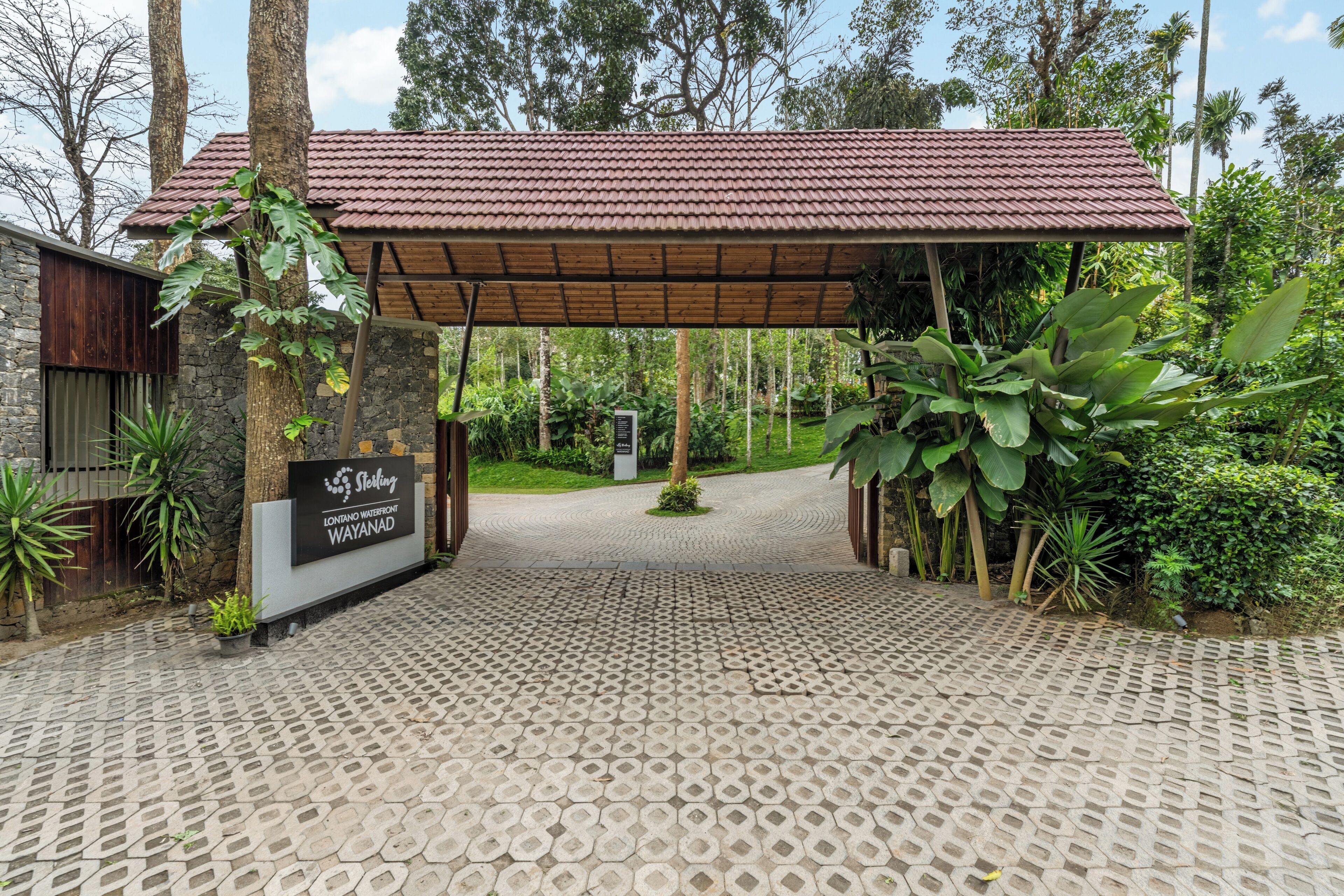 Una entrada techada a un edificio con un letrero que dice 'Sterling Wayanad'.