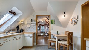 Una cocina con comedor, vista a través de una puerta y una lámpara en el techo.
