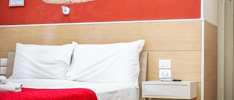 A hotel room with a bed, a nightstand, and a wall with a stone-like texture.