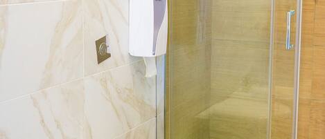 A bathroom with a toilet, bidet, and glass shower enclosure.