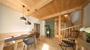 Un interior de madera con una mesa de comedor, sillas, una chimenea y una escalera.