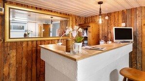 Ein Holzinterieur mit einem großen Spiegel, einer Holztischplatte, einem weißen Stuhl und einem Fernseher.