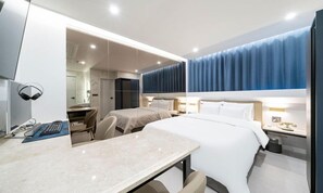 A modern hotel room with a large bed, a desk with a computer, and a separate seating area. - ROSY HOTEL (Cheongju)