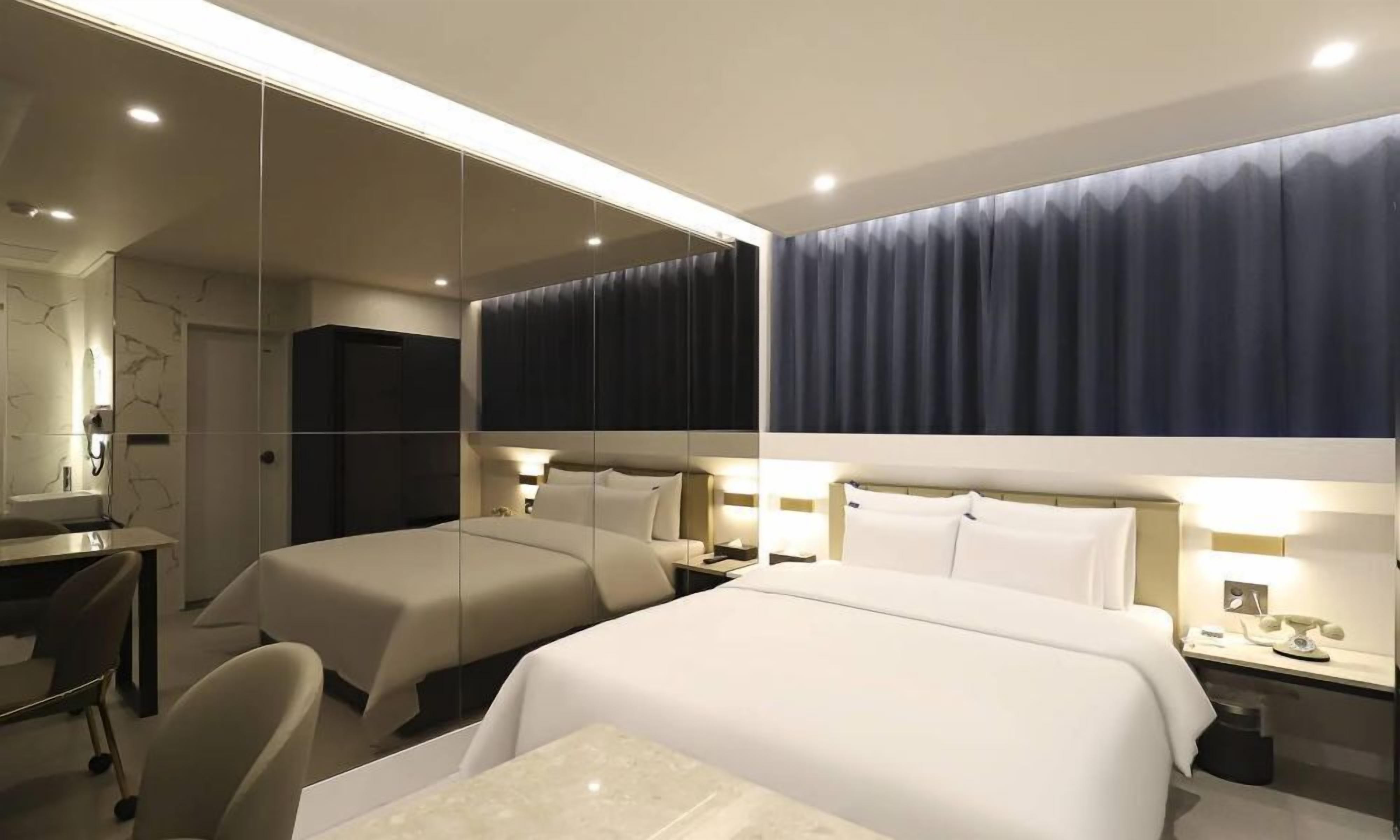 Una habitación de hotel con dos camas, un escritorio y una silla.