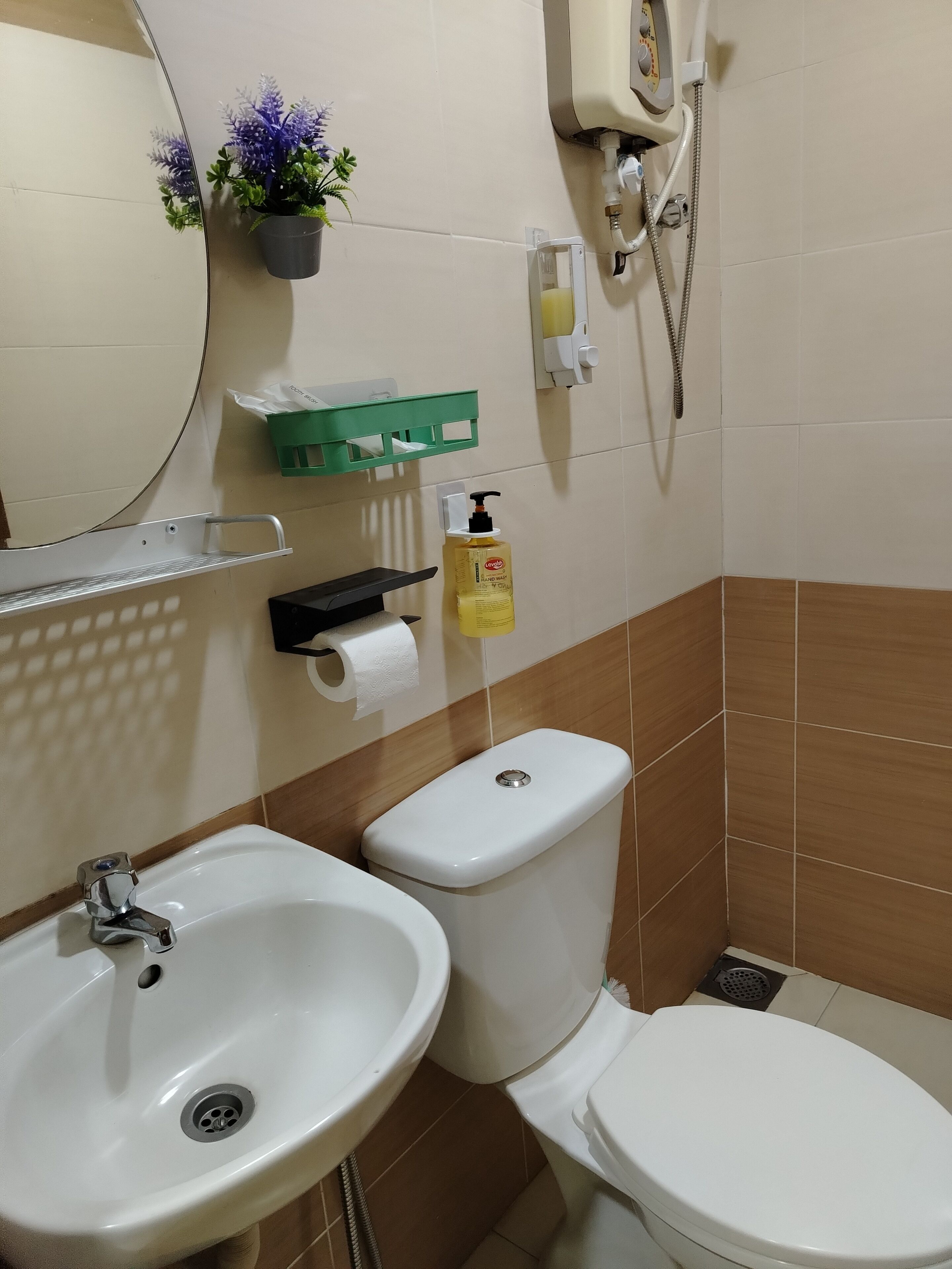 A bathroom with a sink, toilet, and a hand sanitizer dispenser.
