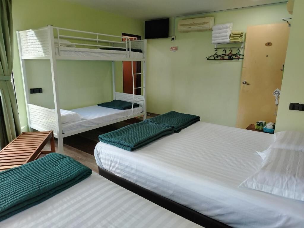 A room with bunk beds, a single bed, and a wooden bench.