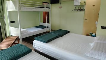 A room with bunk beds, a single bed, and a wooden bench.