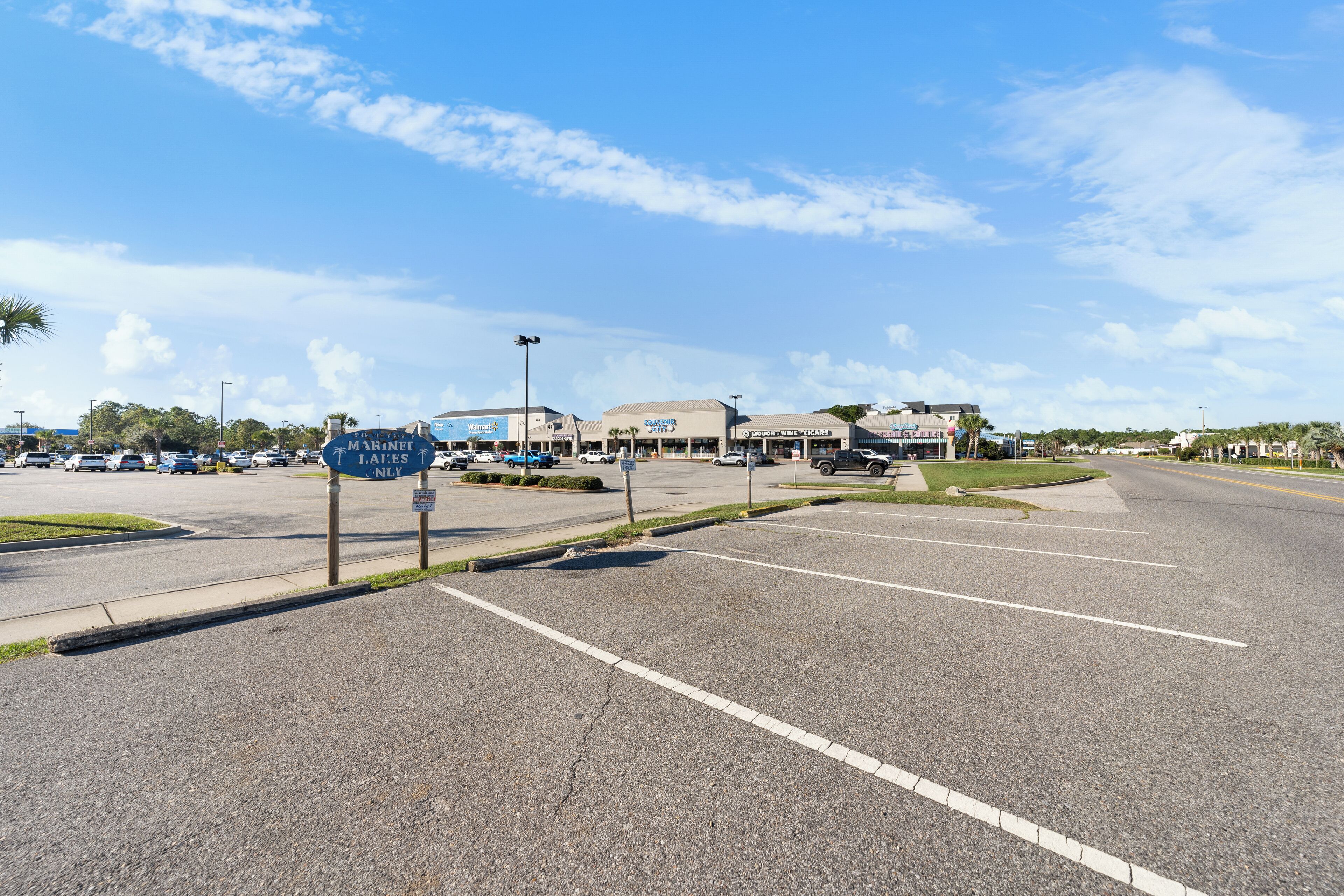 A parking lot with a sign for 'J. Lates NLY' and a building with a 'Walmart' sign in the background.