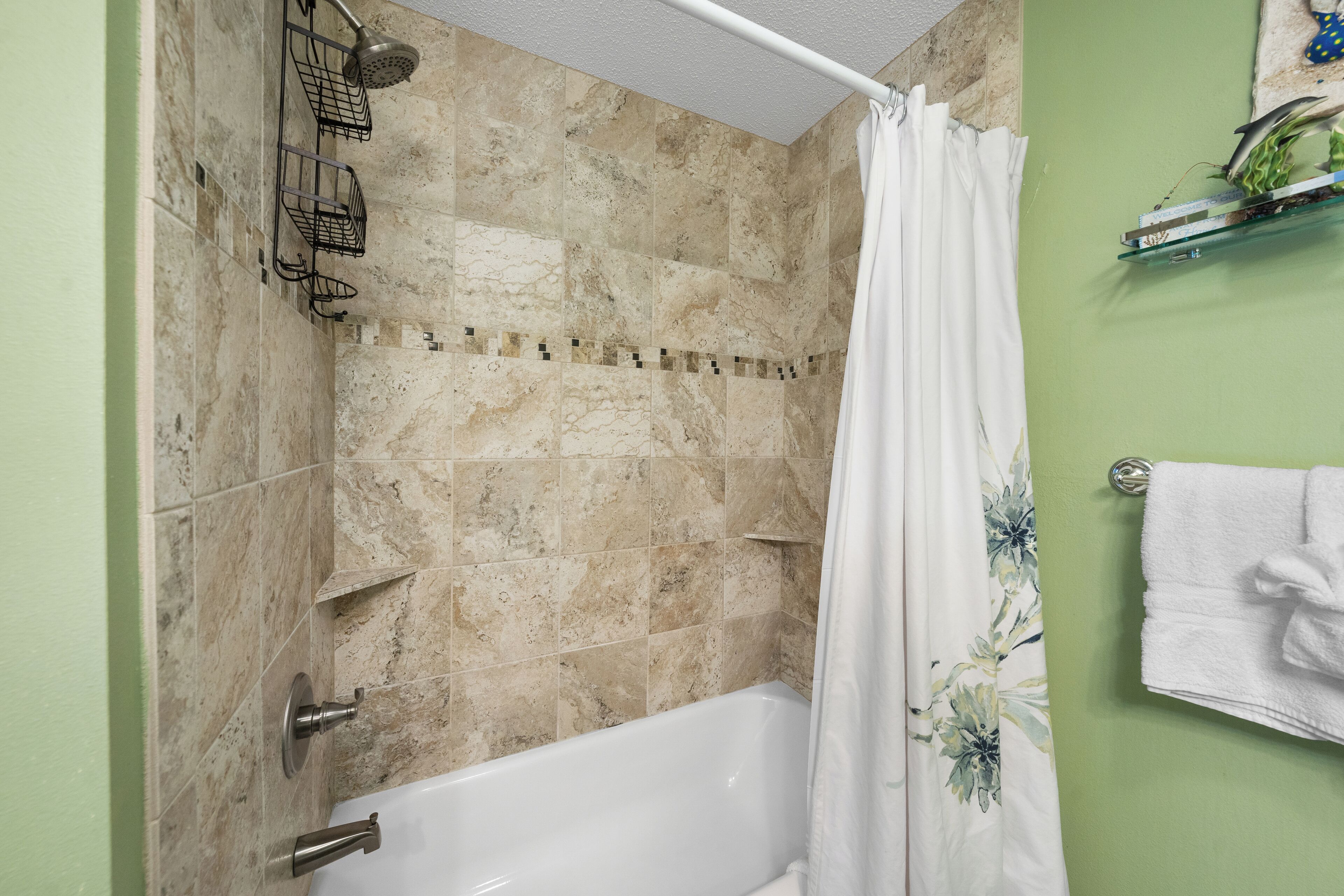 Un baño con bañera, ducha y un perchero para toallas.
