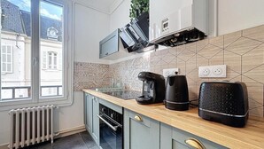 Une cuisine moderne dotée d’un plan de travail en bois, d’un four à micro-ondes encastré, d’une machine à café et d’un grille-pain.
