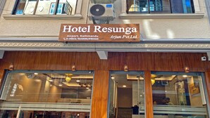 Hotel Resunga con letrero, unidades de aire acondicionado y fachada de madera.