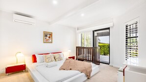 Un dormitorio moderno con una cama grande, una mesita de noche y vistas a zonas verdes.