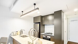 Una cocina moderna con una isla central, electrodomésticos de acero inoxidable y un diseño minimalista.