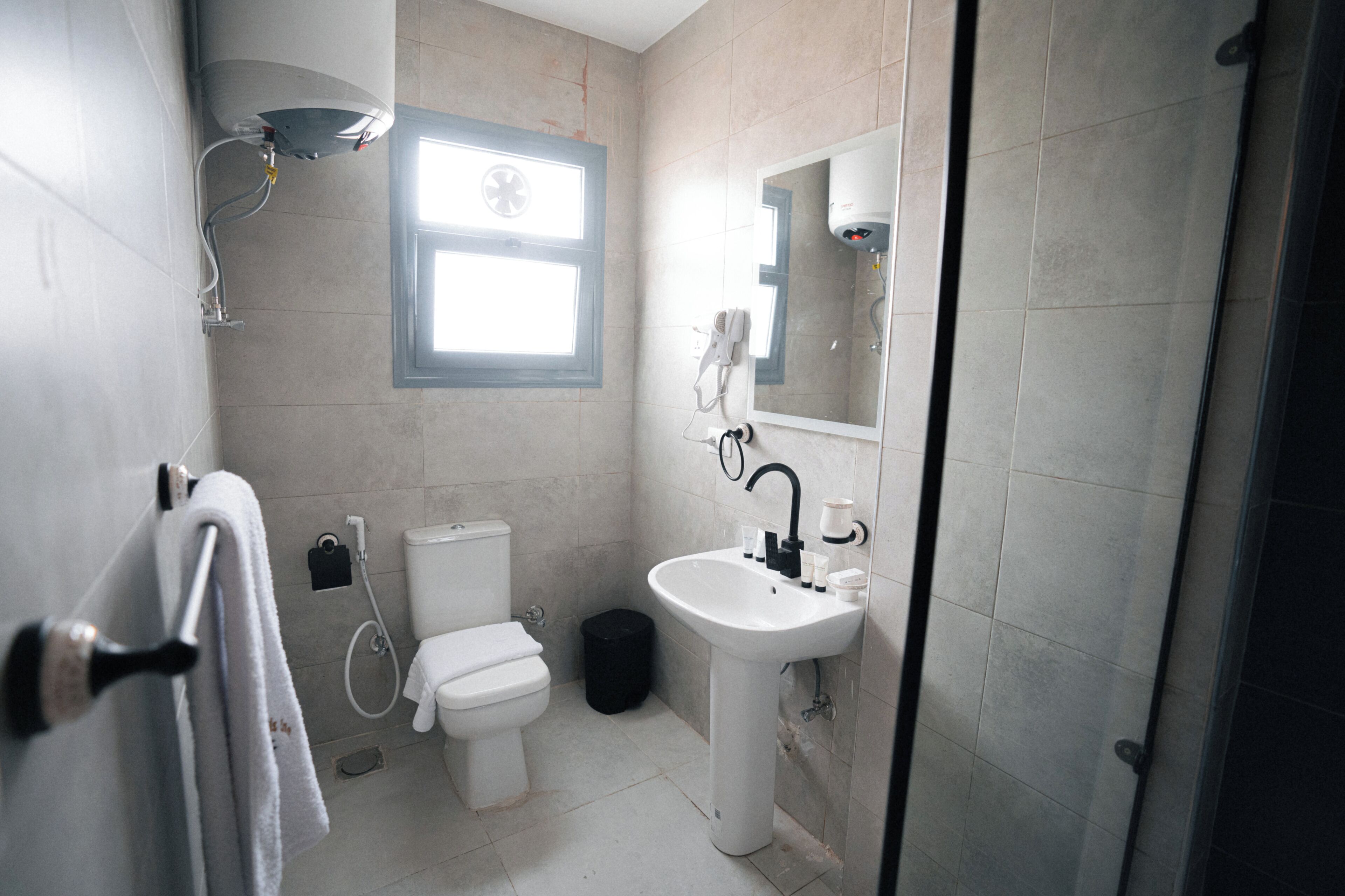 A bathroom with a toilet, sink, and shower.