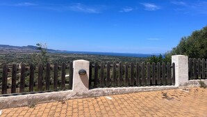 A paved area with a wooden fence and a view of distant landscape.
